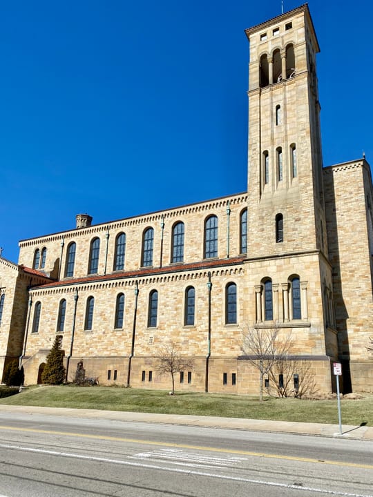 Built between 1929 and 1931, this Romanesque Revival-style church was designed by Joseph Steinkamp to house the congregation of St. William Catholic Church, founded in 1909.  Towering over the corner of West 8th Street and Sunset Avenue, the sandstone-clad church features a red tile roof, roman arch