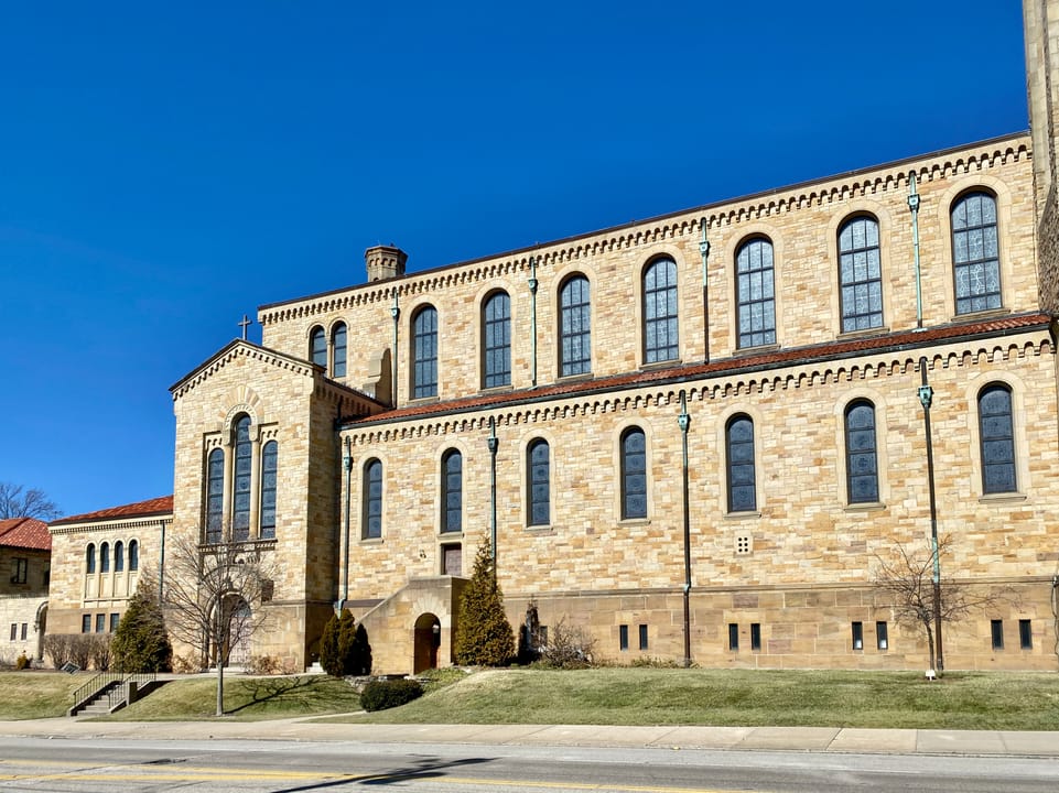 Built between 1929 and 1931, this Romanesque Revival-style church was designed by Joseph Steinkamp to house the congregation of St. William Catholic Church, founded in 1909.  Towering over the corner of West 8th Street and Sunset Avenue, the sandstone-clad church features a red tile roof, roman arch