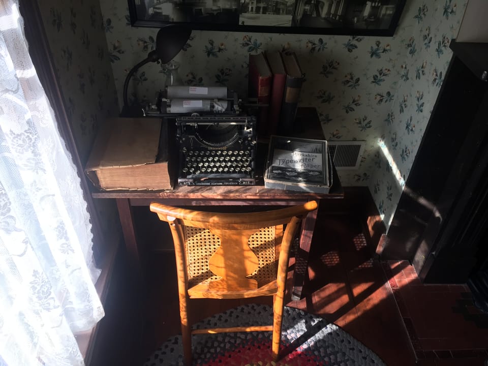 A period writing desk with an antique Underwood typewriter and a box of "Berkshire Typewriter Paper," part of the Thurber House's interior exhibits.