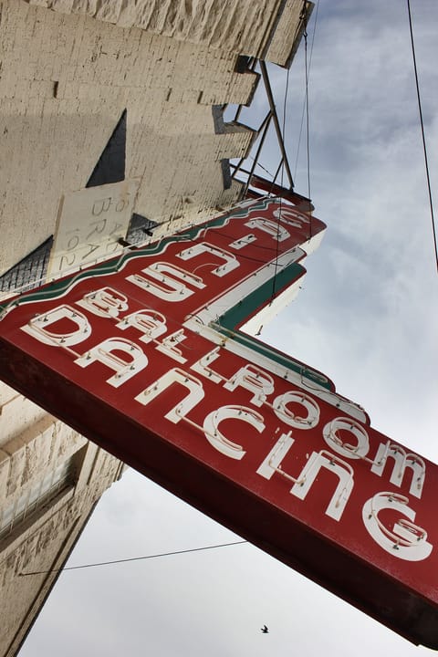 A low-angle view of Cain's Ballroom's red neon 'Ballroom Dancing' sign