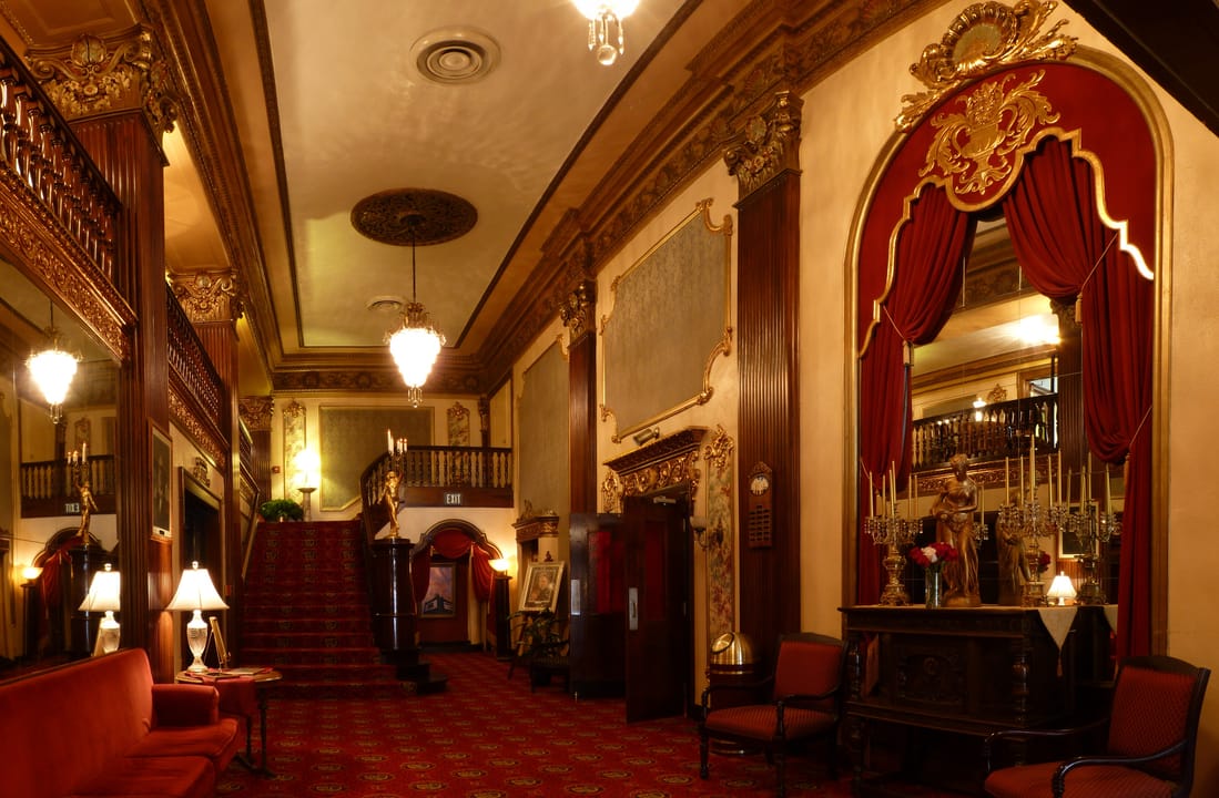 The grand lobby of the Coleman Theatre, Miami, Oklahoma, with the gilded staircase, red carpet and ornate mirror.