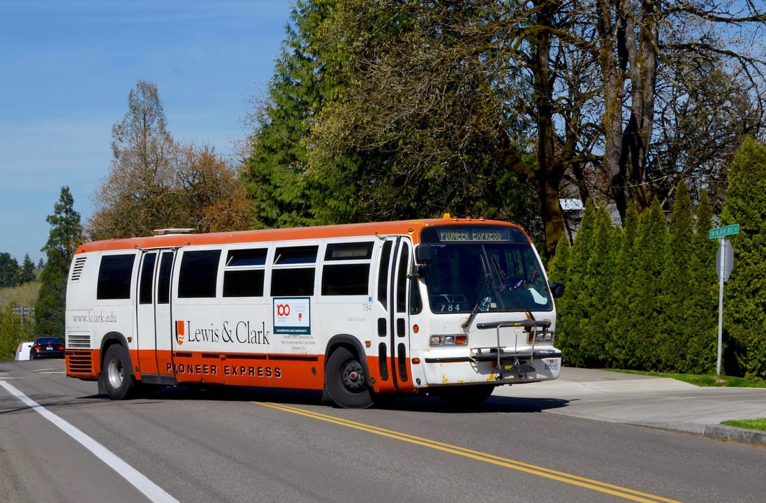 Pioneer Express bus 784 turning into the Lewis &amp; Clark College campus (onto Huddleson Lane) from Palatine Hill Road, in Portland, Oregon. Bus 784 is a 1994 TMC RTS-type bus (specifically, model T80206) and was originally Fairfax Connector bus 7842 (Fairfax, Virginia).  It was acquired secondhand