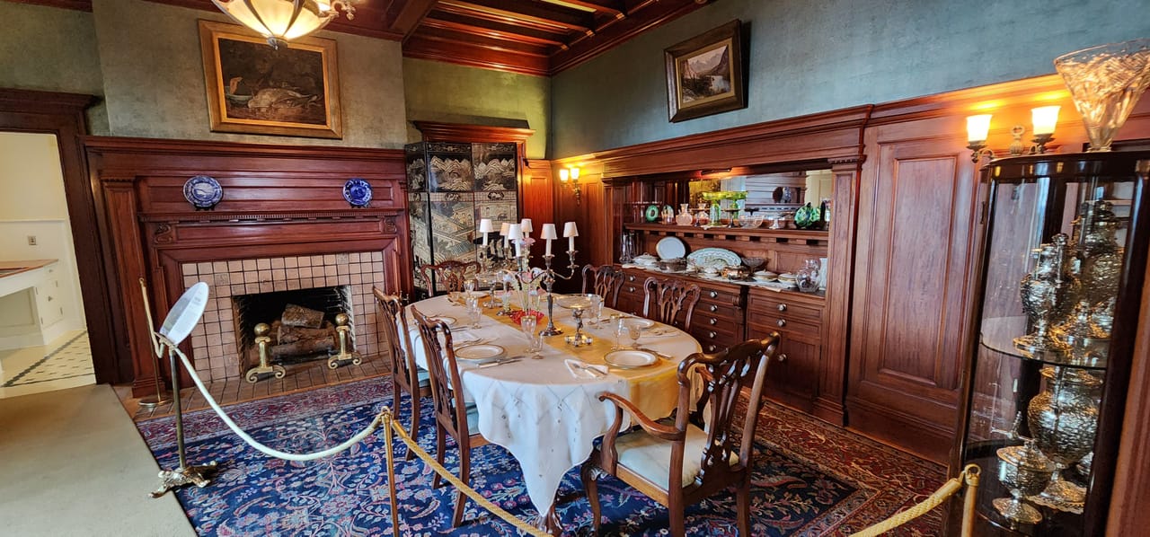 The formal dining room of the Pittock Mansion, Portland, Oregon, set with period table linens and china.