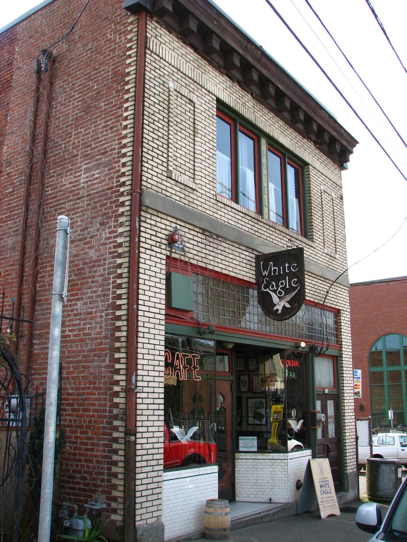 Two-story brick facade of the White Eagle Saloon and Hryszko Brothers Building at 836 N Russell Street in Portland, Oregon, a National Register property now operated by McMenamins