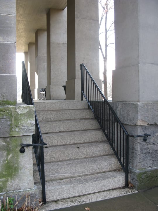 Granite steps with iron railings rising under the columned portico of the Baker Mansion in Altoona, Pennsylvania, December 2008.