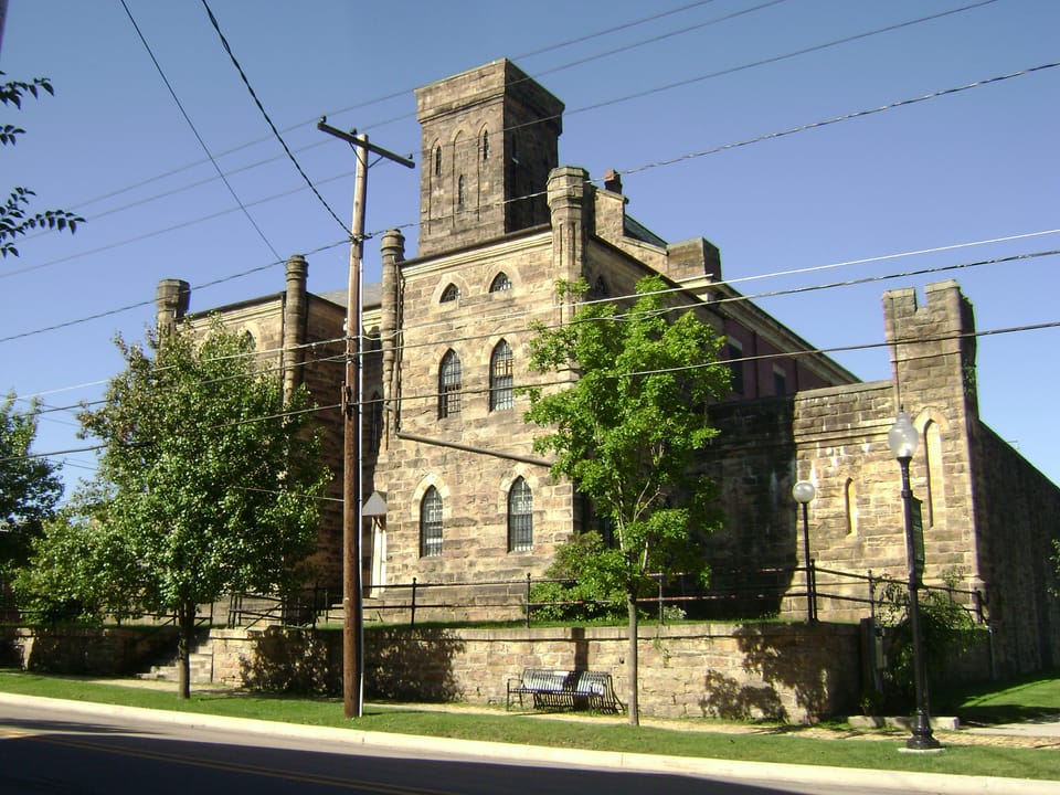 Street-corner view of the original 1872 castellated Gothic Revival jail building, showing its central tower and pointed-arch windows, Ebensburg, Pennsylvania.
