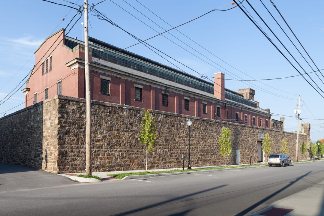 The south and west sides of the Cambria County Jail, showing the 1910 brick extension above the original stone wall, Ebensburg, Pennsylvania.