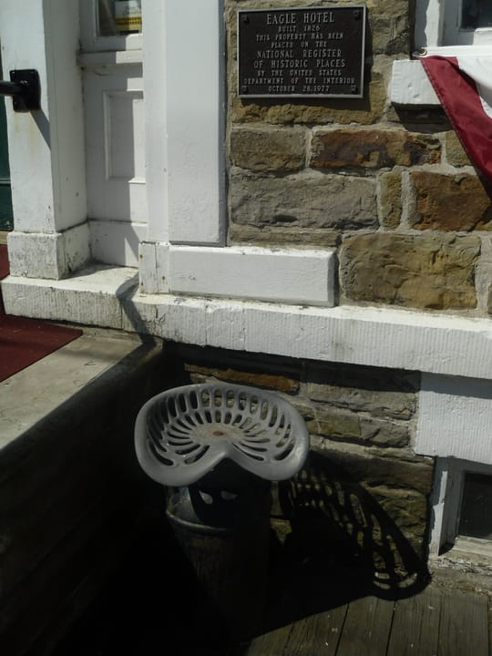 The National Register of Historic Places plaque on the Eagle Hotel's fieldstone wall in Waterford, Pennsylvania, dated October 28, 1977, reading 'Eagle Hotel, Built 1826.'