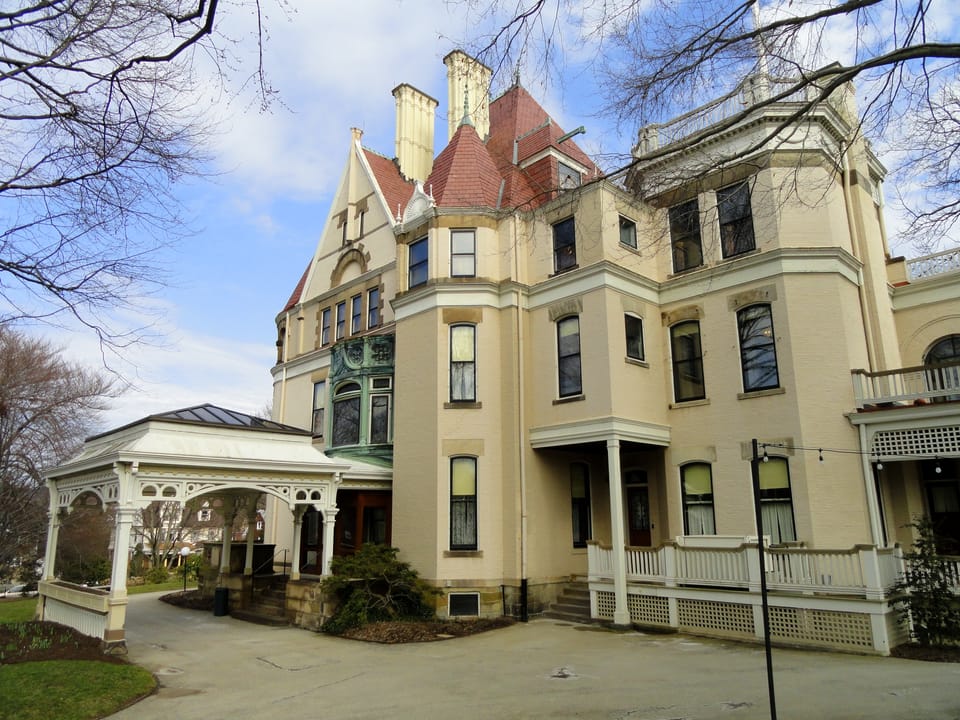 Gabled front facade of Clayton showing the steep slate-topped dormers, chimneys and the white porte-cochere, March 2012.