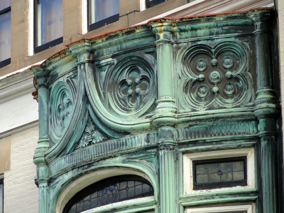 Close-up detail of Clayton's ornate verdigris copper window surround with quatrefoil carving, March 2012.