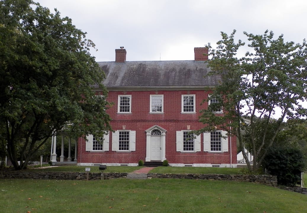 The rear of the Edward Hand House at Rock Ford, shaded by mature trees.