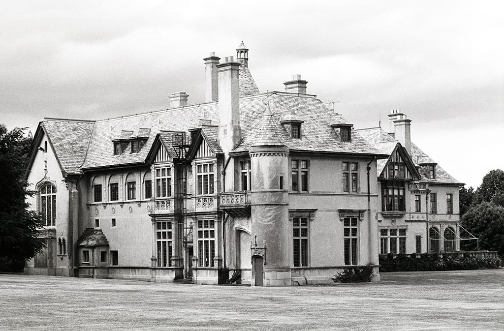 A black-and-white 1998 view of Carey Mansion (Seaview Terrace), Newport, Rhode Island, closer on the round corner turret and the half-timbered Tudor wing.