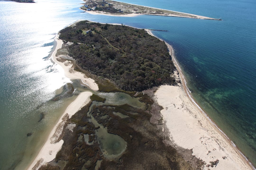 An aerial view of the sand spit and breakwater at the north end of Block Island, looking toward Sandy Point and the Block Island National Wildlife Refuge that surrounds it.