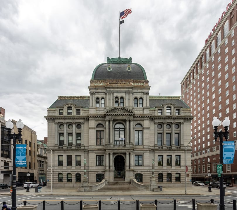 Providence City Hall's front facade and flag-topped dome, seen straight-on from Dorrance Street with the Providence Biltmore behind it, 2021.