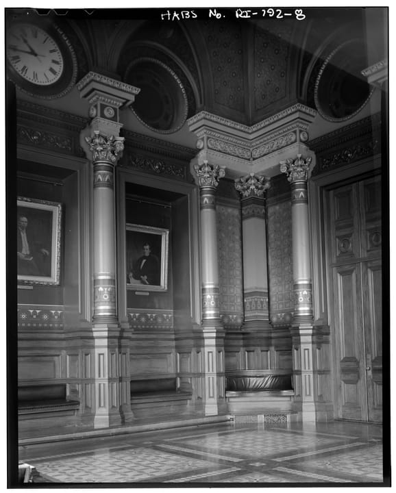 The Aldermen Chamber inside Providence City Hall, looking southwest at its columned walls and framed portraits; Historic American Buildings Survey documentation (HABS RI,4-PROV,92-8).