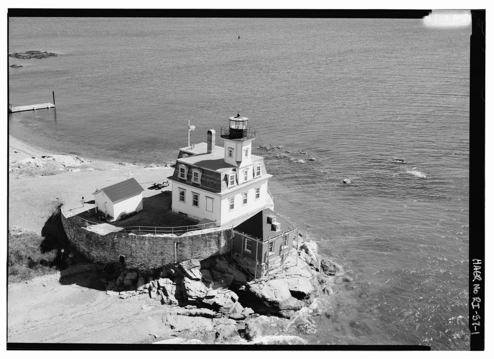 A black-and-white HAER aerial view of Rose Island Lighthouse atop the southwest bastion of Fort Hamilton, with Narragansett Bay around it.