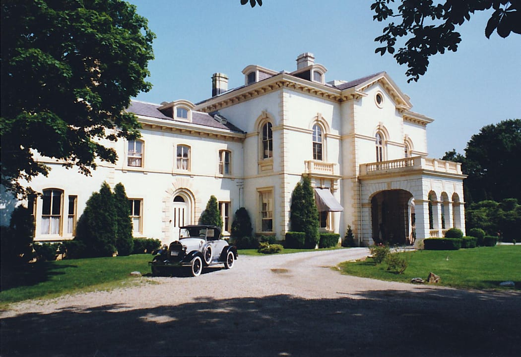 Beechwood's front entrance and porte-cochere with a period automobile in the driveway, Newport, Rhode Island.