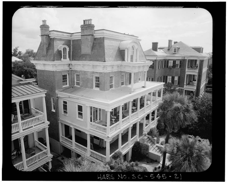 An elevated three-quarter view of the Stevens-Lathers House (20 South Battery), Charleston, South Carolina, showing the mansard roof and stacked piazzas.