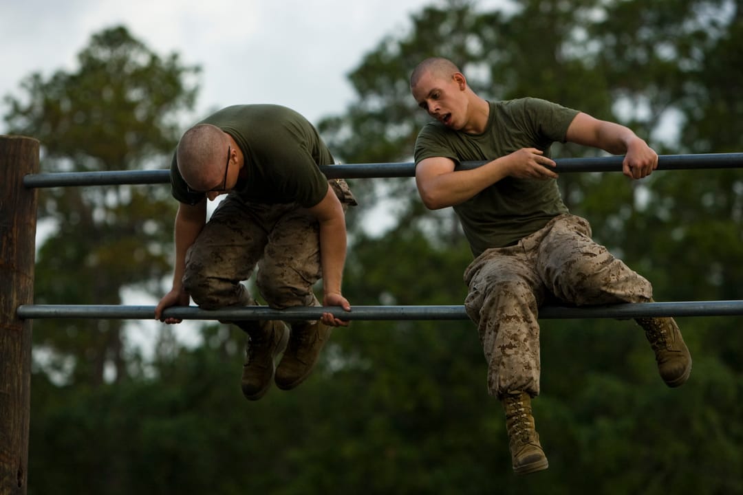 U.S. Marine Corps recruit Caleb McCready, left, and recruit Mark Fiasconaro, both with Platoon 3060, Kilo Company, 3rd Recruit Training Battalion, flip over a set of double bars on an obstacle course, June 10, 2013, at Parris Island, S.C. The obstacle course was a combat conditioning tool used to bu
