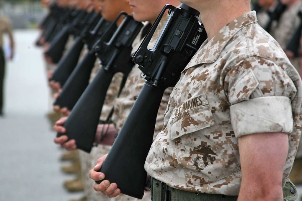 Recruits from Hotel Company grip their rifles by the butt stock during a close order drill maneuver called right shoulder arms at Peatross Parade Deck, March 30, during the company's Final Drill event. Final Drill tests each platoon's precision, uniformity and overall mastery of close order drill. 
