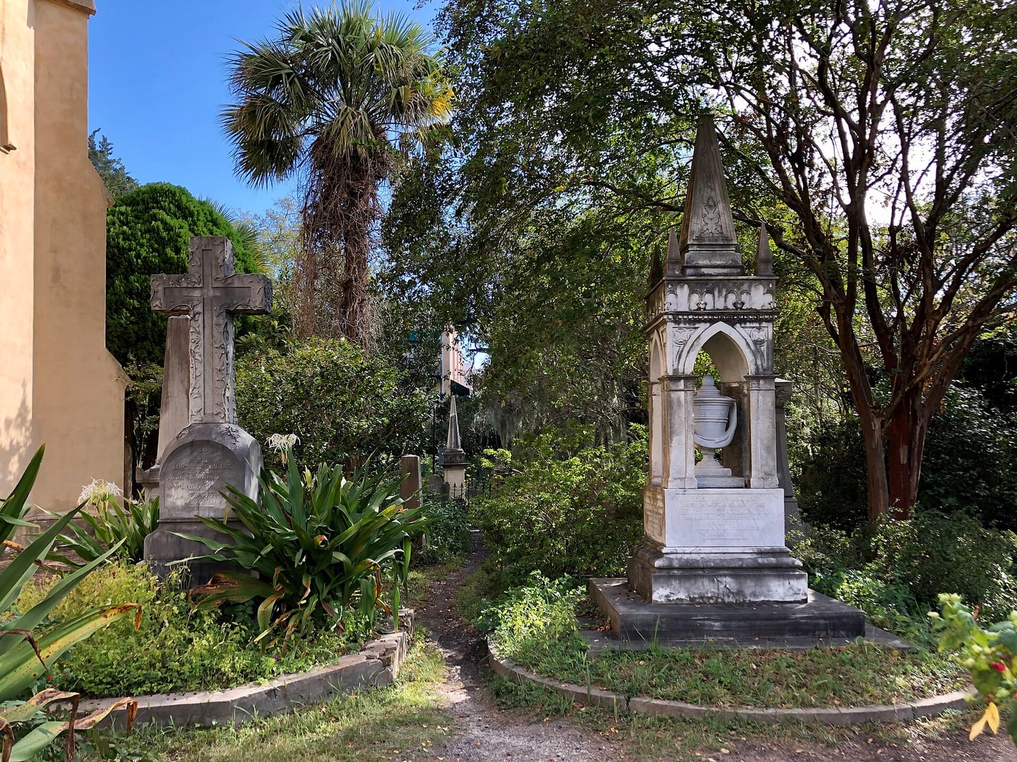 Wildly overgrown cemetery grounds at the Unitarian Church in Charleston, with weathered tombstones and verdant ivy under shady trees in Harleston Village.