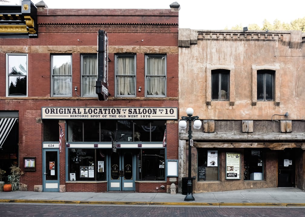 The brick storefront at 624 Main Street in Deadwood, South Dakota, marked with a painted sign as the original location of Saloon No. 10, where Wild Bill Hickok was shot in 1876; today's Old Style Saloon No. 10 is at 657 Main Street.