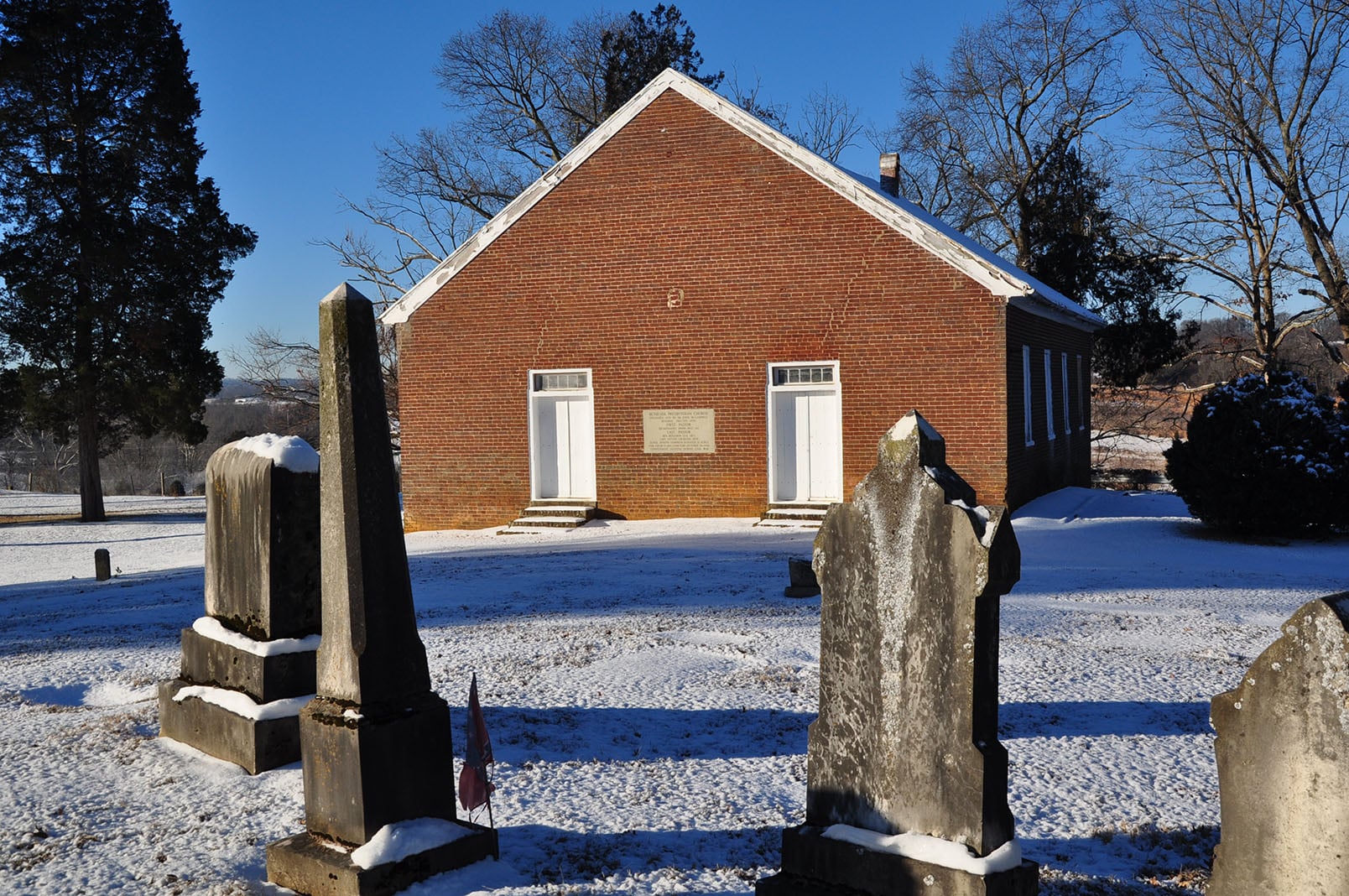 The 1835 brick facade of Bethesda Presbyterian Church in Morristown, Tennessee in winter, with the Civil War-era cemetery visible to the right
