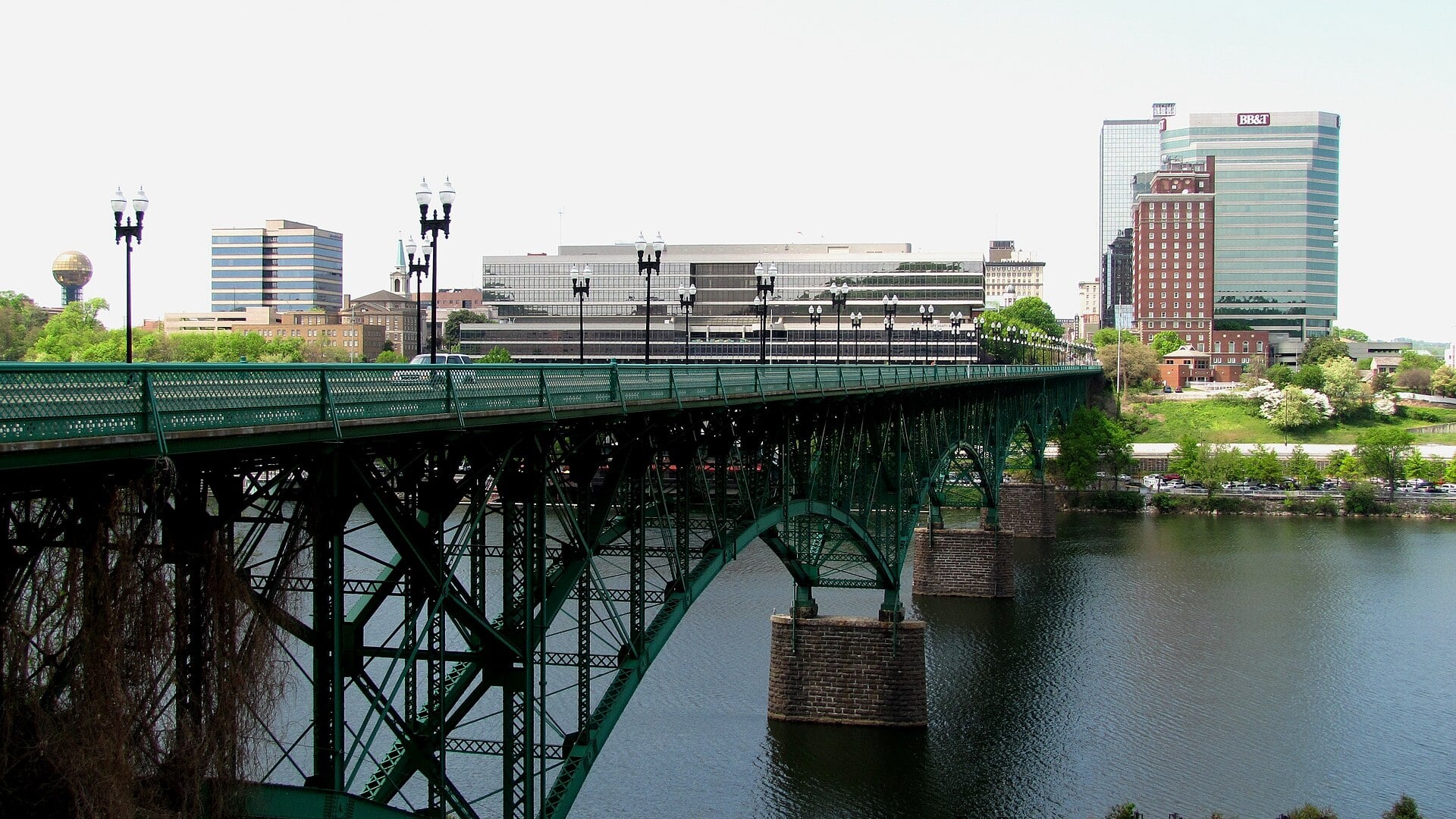 Gay Street Bridge (1898) spanning the Tennessee River with the Knoxville skyline including the Sunsphere visible in the background.