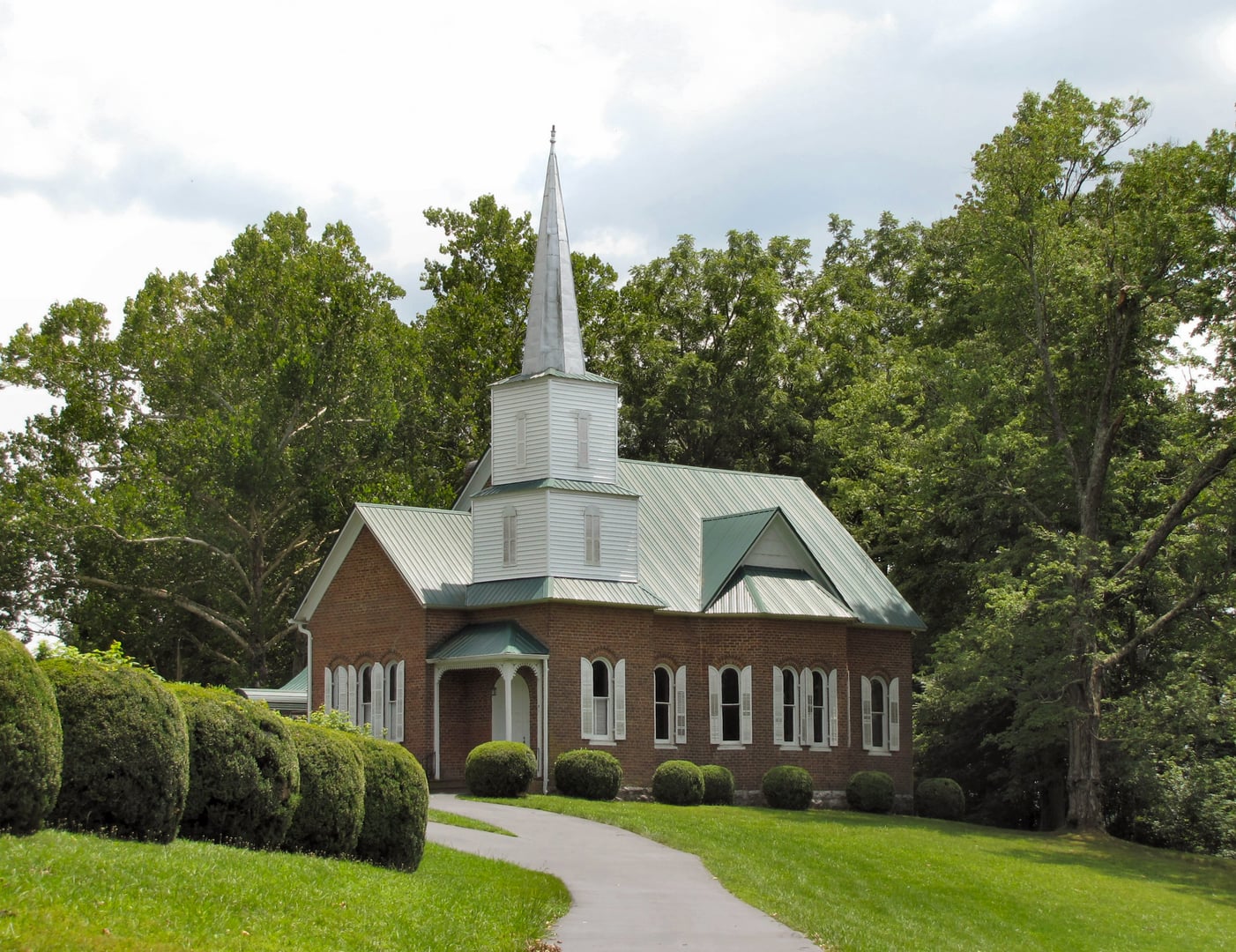 Stone graves and church building at New Providence Presbyterian Cemetery on a hilltop in Surgoinsville Tennessee