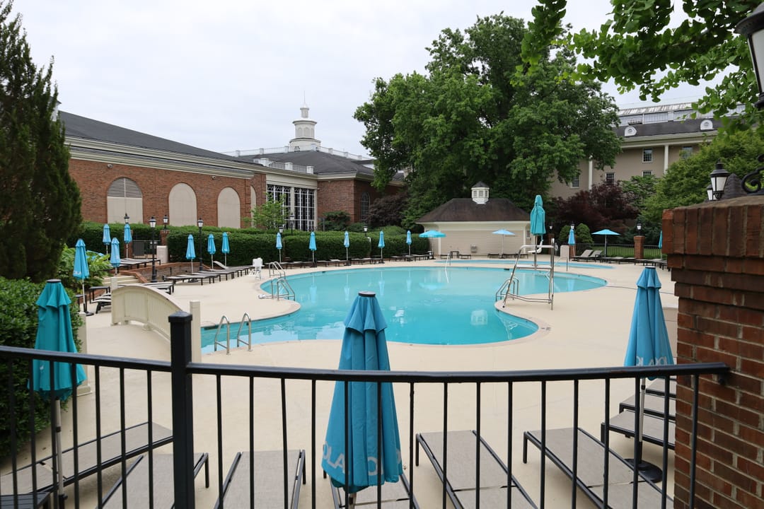 Outdoor swimming pool courtyard at the Gaylord Opryland Resort, with a brick guest wing and cupola behind, 2022.