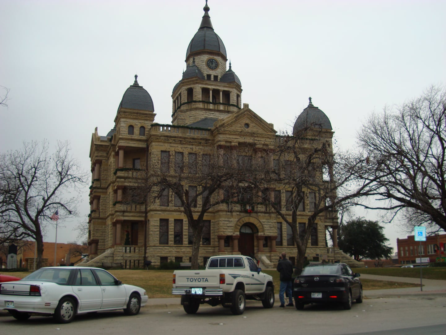 The 1896 Denton County Courthouse-on-the-Square, a Romanesque Revival limestone building with central clock tower on the Denton TX downtown square
