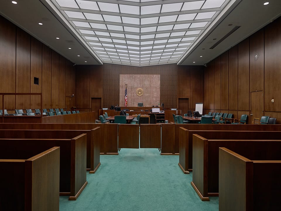 A wood-paneled federal courtroom inside the Bob Casey Federal Courthouse, Houston, with the judge's bench, jury box and public gallery.