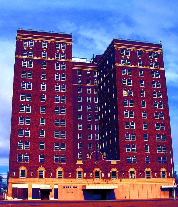 The 14-story Art Deco brick tower of the Herring Hotel in downtown Amarillo, Texas, photographed from street level showing its distinctive massing and boarded lower floors