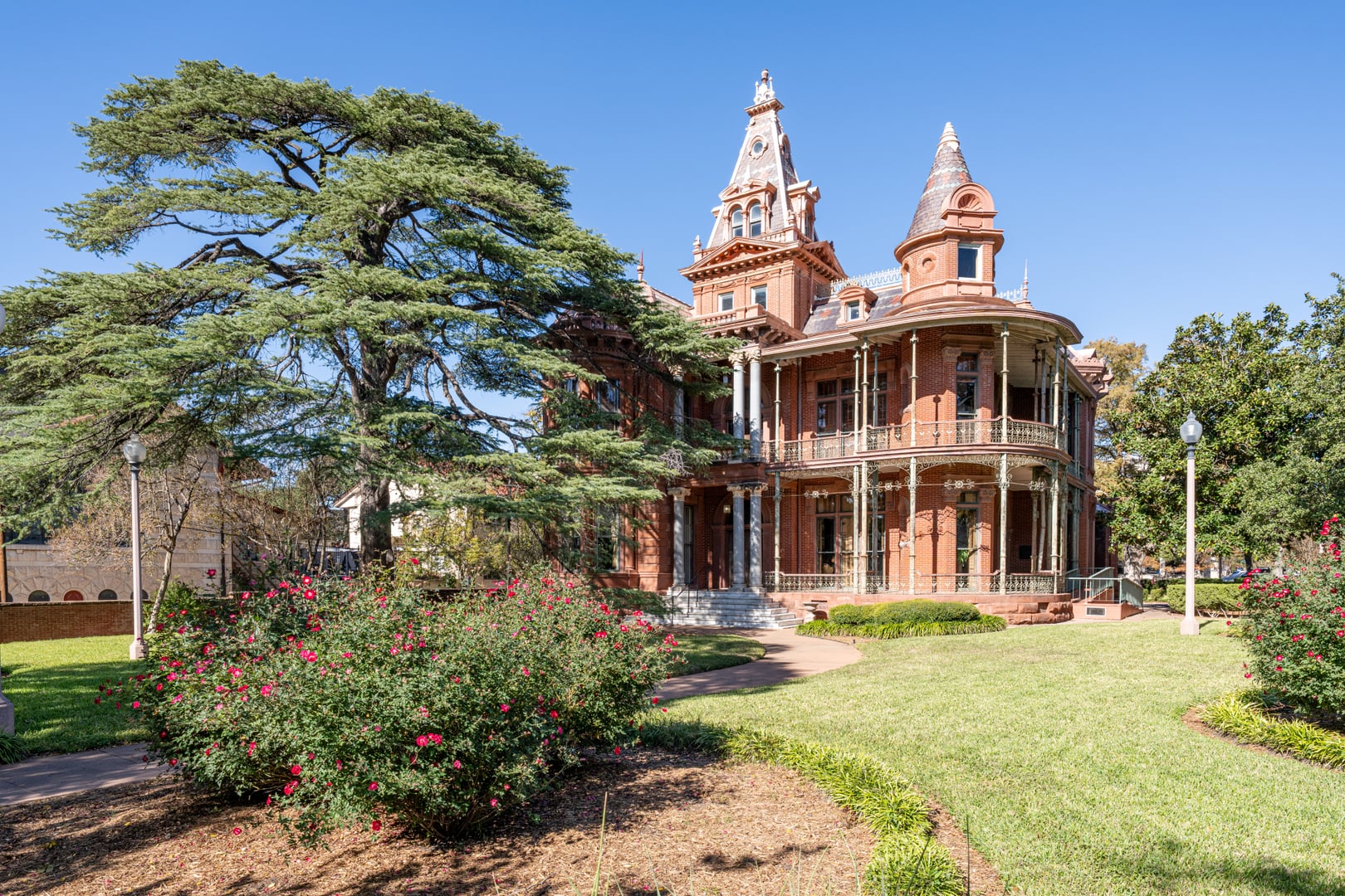 Victorian Littlefield House with mismatched towers and multicolored slate roof on the UT Austin campus