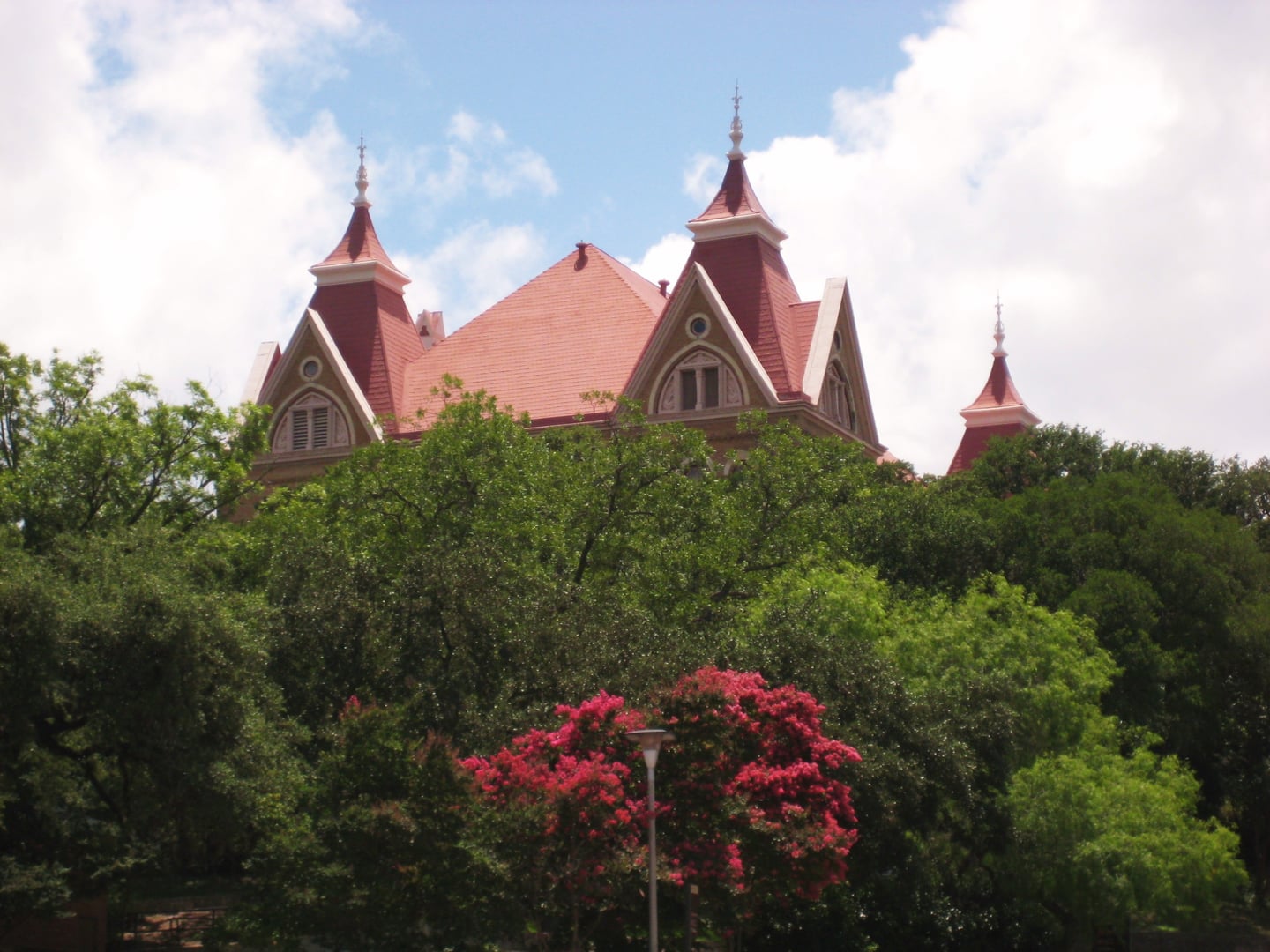 Old Main at Texas State University in San Marcos, Texas — the 1903 Victorian Gothic building with red roof that was the campus's first and only structure until 1908