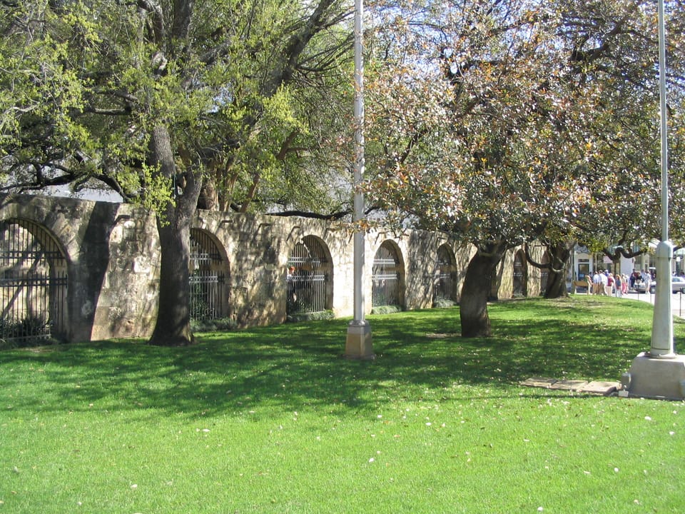 The arched colonnade along the Alamo grounds, part of the historic mission compound in San Antonio, Texas