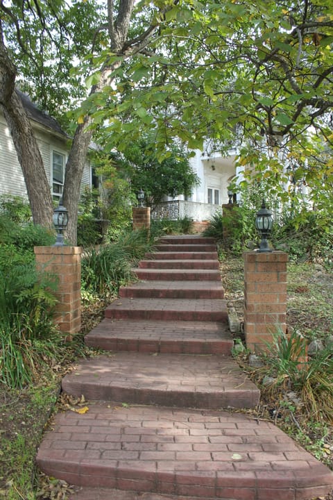 The brick walkway and steps leading up through the oaks to Victoria's Black Swan Inn's front porch.