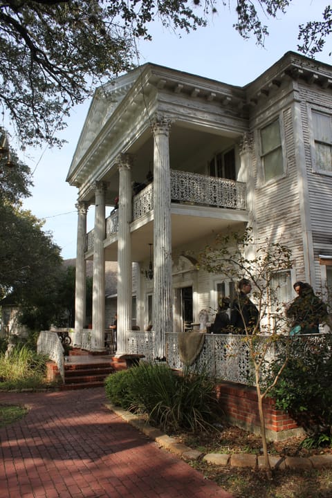 Victoria's Black Swan Inn's three-story colonnaded porch, seen from the brick front walkway.