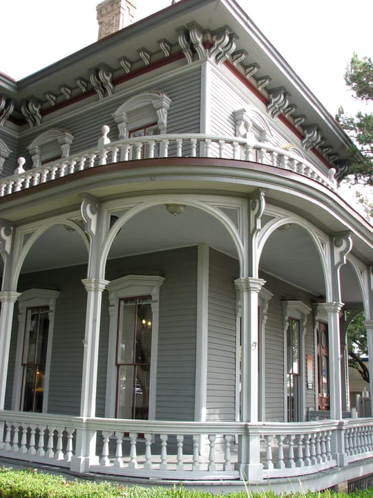 Close view of the Walter Tips House's curved, two-story wraparound porch with turned balustrade, 2008.