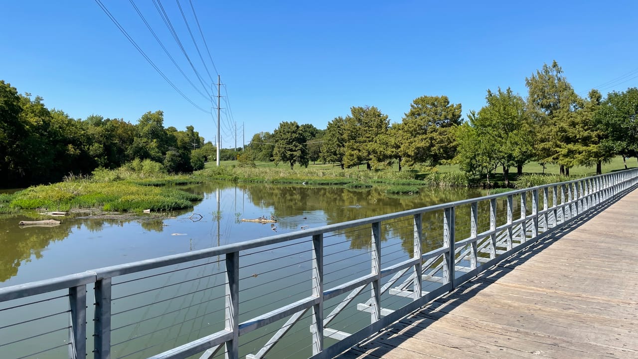 The pedestrian and cycling boardwalk bridge crossing a marshy inlet of White Rock Lake, September 2022.