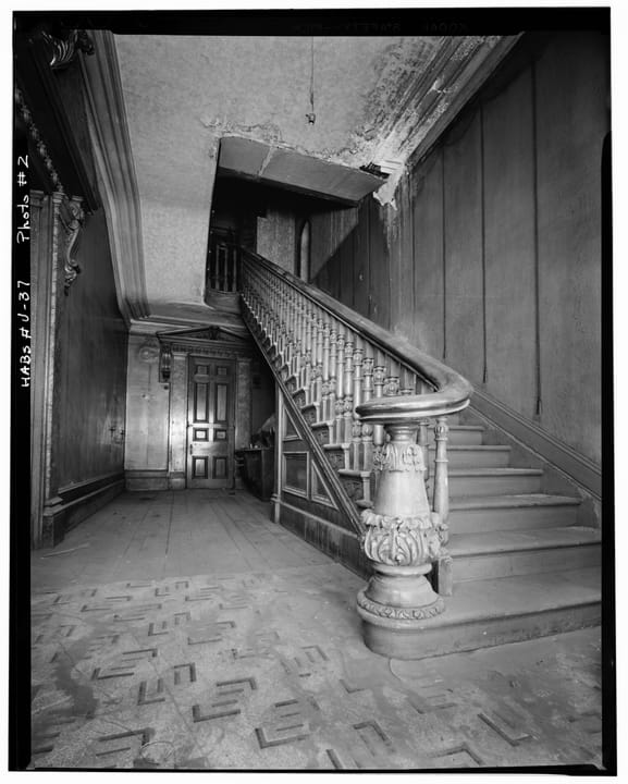 The mansion's principal staircase with its carved newel post and balustrade, photographed for the federal historic-building record, 1967.