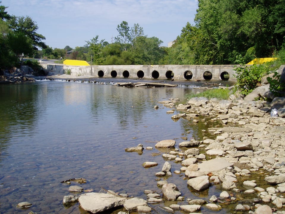 The old bridge crossing at Wiley Drive before project  construction.  Culverts in the previous bridge were undersized and elevated above the bed of the river, effectively blocking upstream fish migration in low flow periods and exacerbating flood events.  Credit: USFWS.