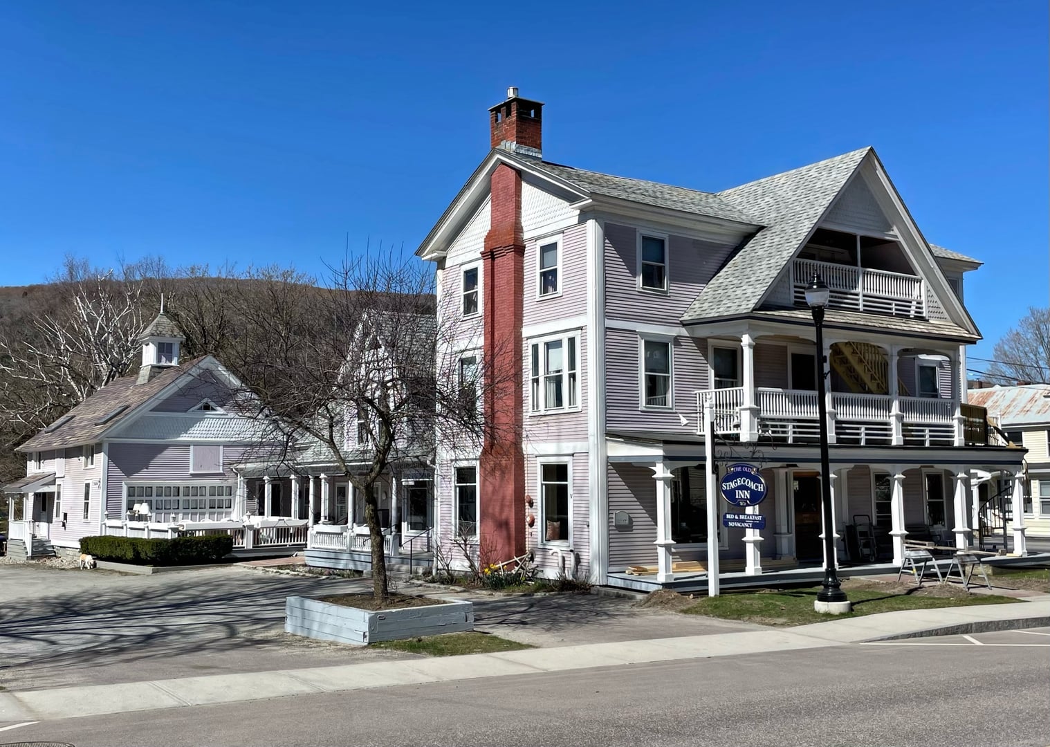Federal-style 1826 inn with white clapboard siding and porch in Waterbury Village, Vermont