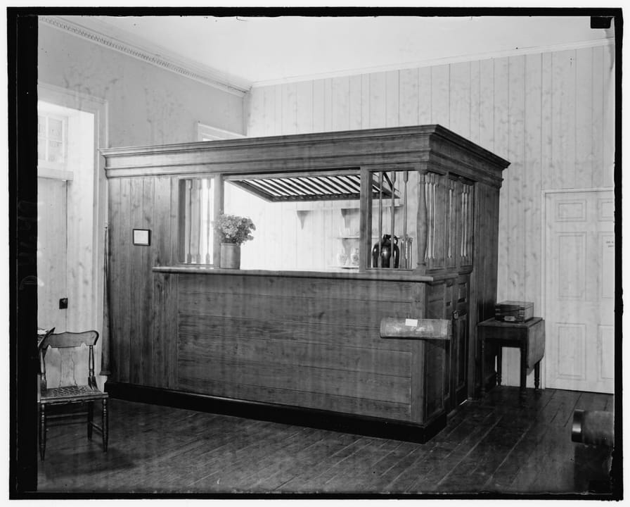 The historic wooden bar/taproom counter inside Gadsby's Tavern, photographed in 1938 by Harris & Ewing. (The Commons file title says 'Exterior' but the image itself shows the tavern's interior bar room; captioned here for what it actually depicts.)