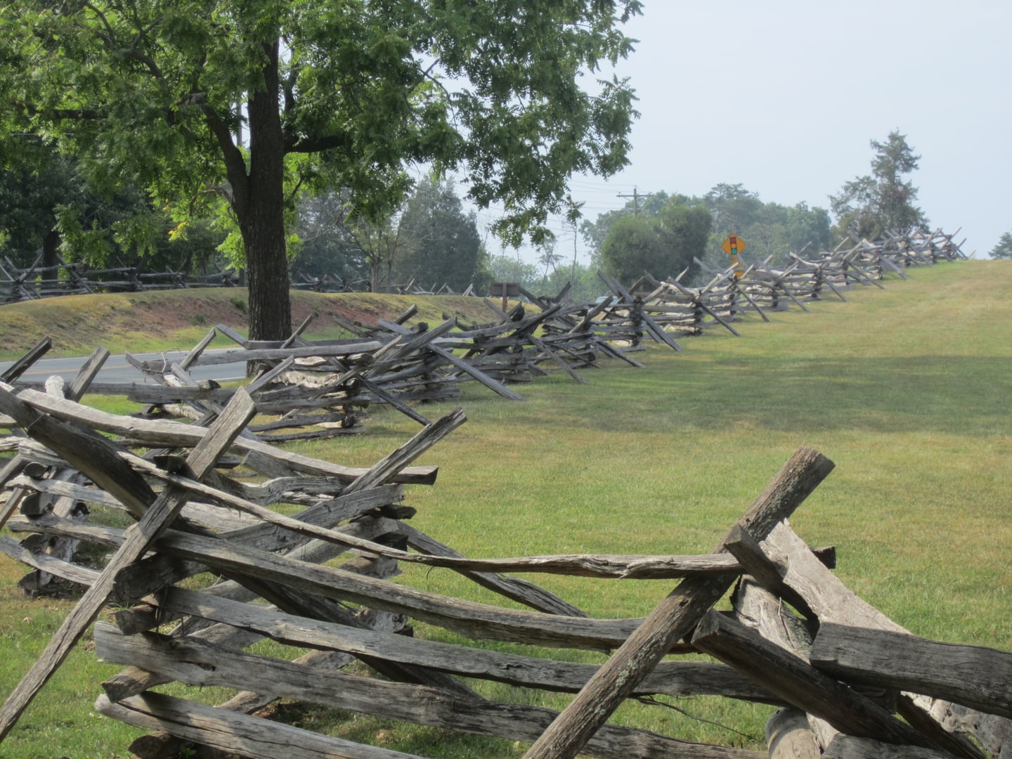 A period-style wooden fence runs across the preserved Civil War battlefield at Manassas National Battlefield Park in Virginia