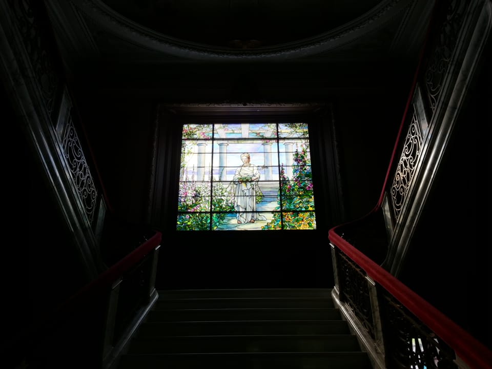 The marble main staircase and Tiffany stained glass window at Swannanoa, viewed from the stair landing