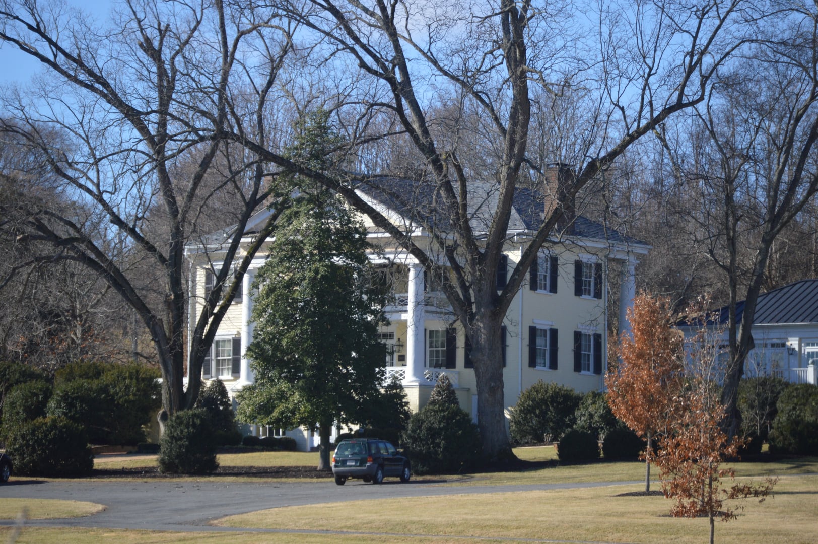 Federal-style brick manor house at The Inn at Willow Grove with willow trees in foreground