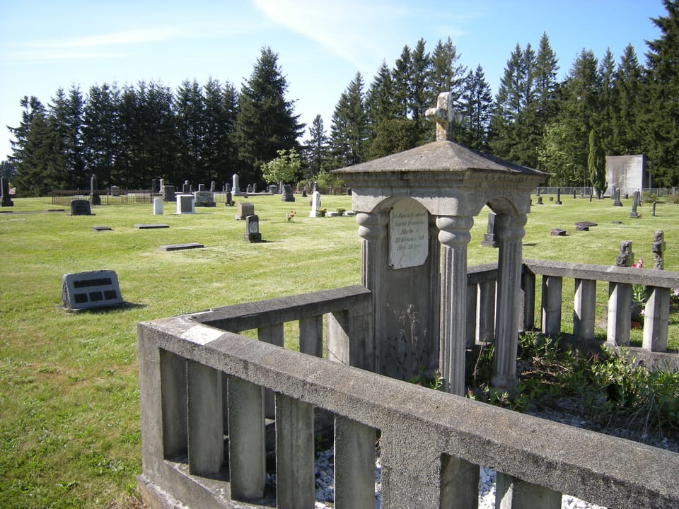 A columned stone grave monument among rows of headstones at Black Diamond Cemetery, Black Diamond, Washington, 2009.