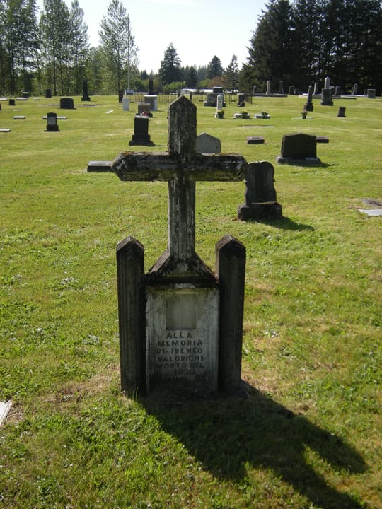 A weathered stone cross grave marker at Black Diamond Cemetery, Black Diamond, Washington; many of the cemetery's older graves carry Italian-language inscriptions from the area's immigrant mining community, 2009.