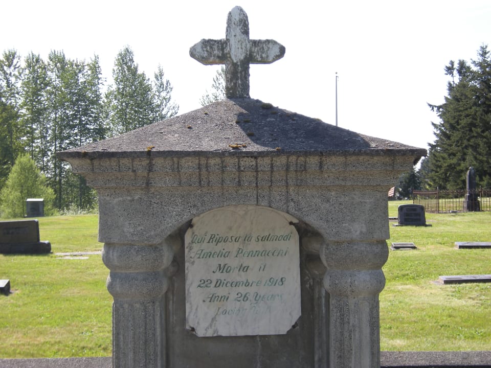 A columned stone tomb topped with a cross at Black Diamond Cemetery, Black Diamond, Washington; the Italian-language inscription is typical of the cemetery's older immigrant-era graves, 2009.